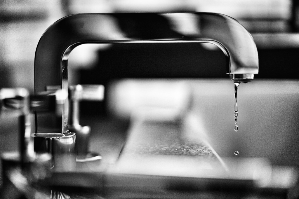 Water drops coming out of the faucet.