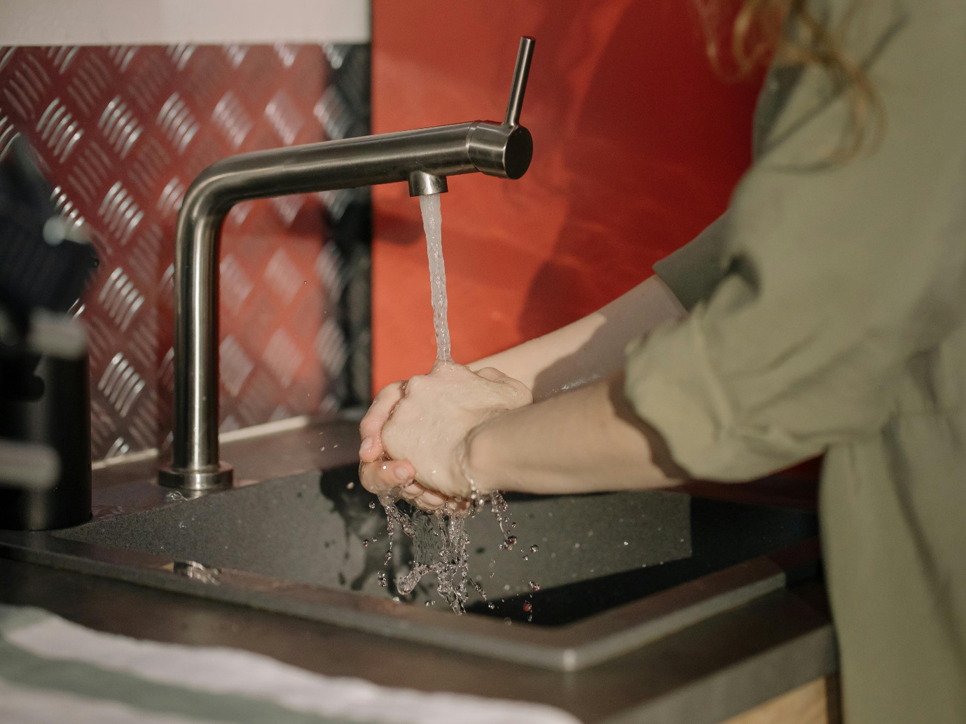 a person using a silver faucet