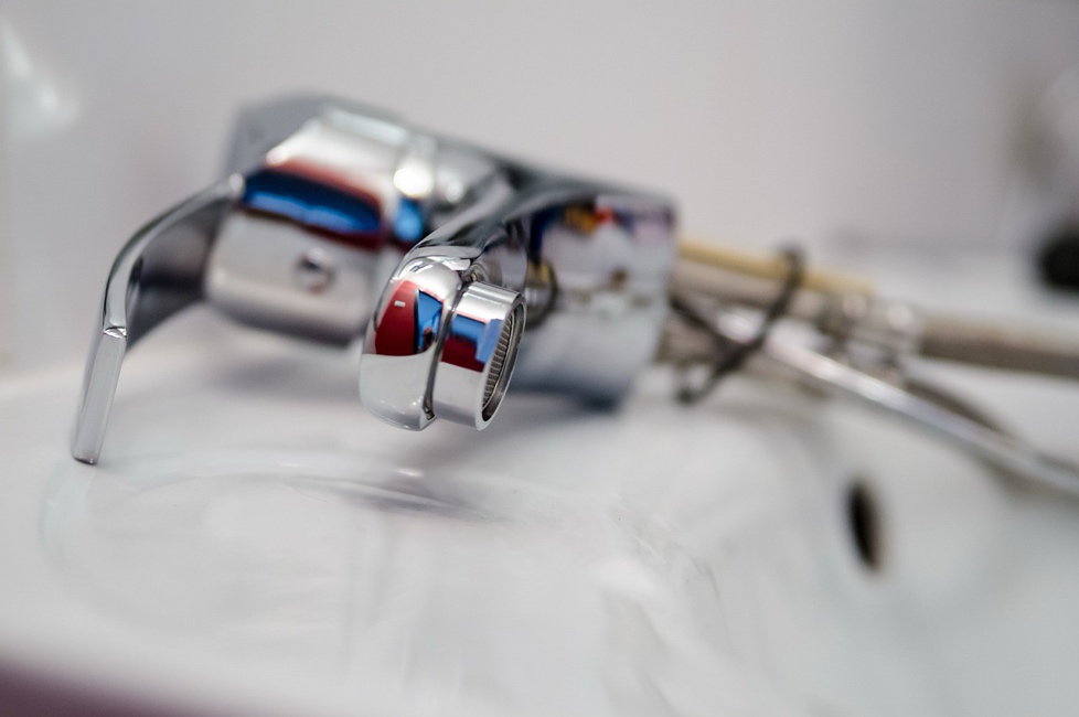 Plumber repairing a leaking tap with tools