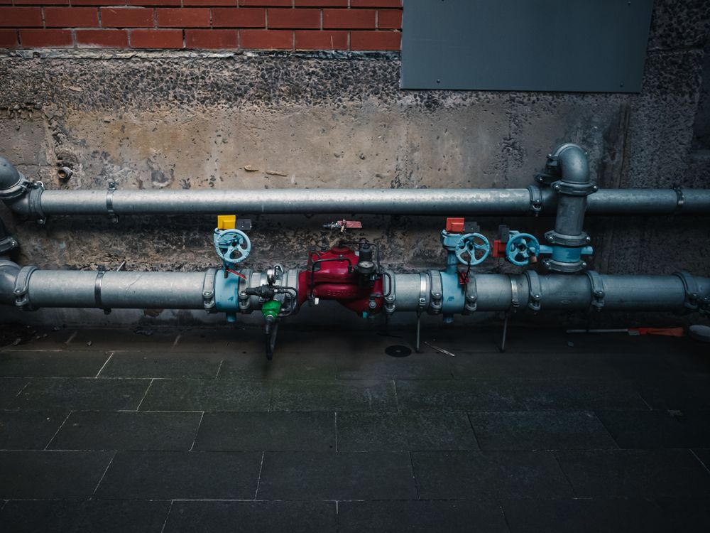 A picture shows a detailed view of industrial pipes with colorful valves. 
