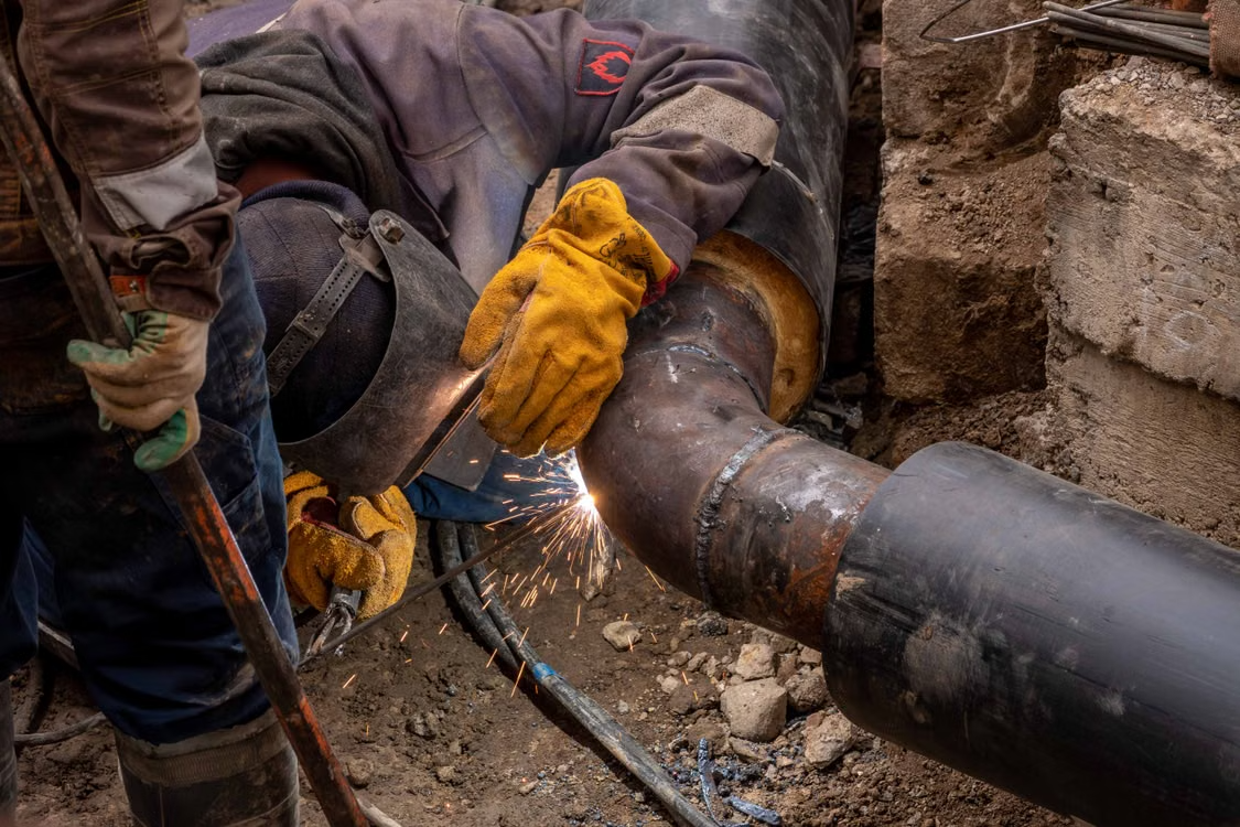  Close-up of hands fitting steel pipe sections together.